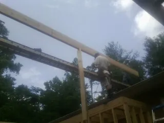 Carpenter setting a ridge beam over a new addition frame — Ice Dam Removal by Roofing Brothers in Steubenville