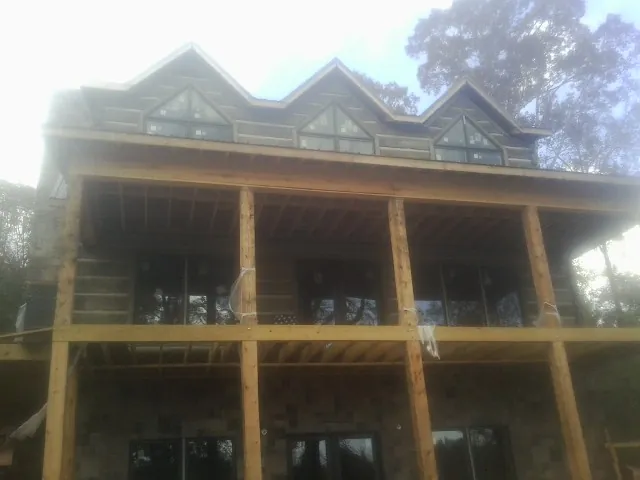 Dormers and porch framing on a large log home under construction — Roof Coating work by our crew in Steubenville