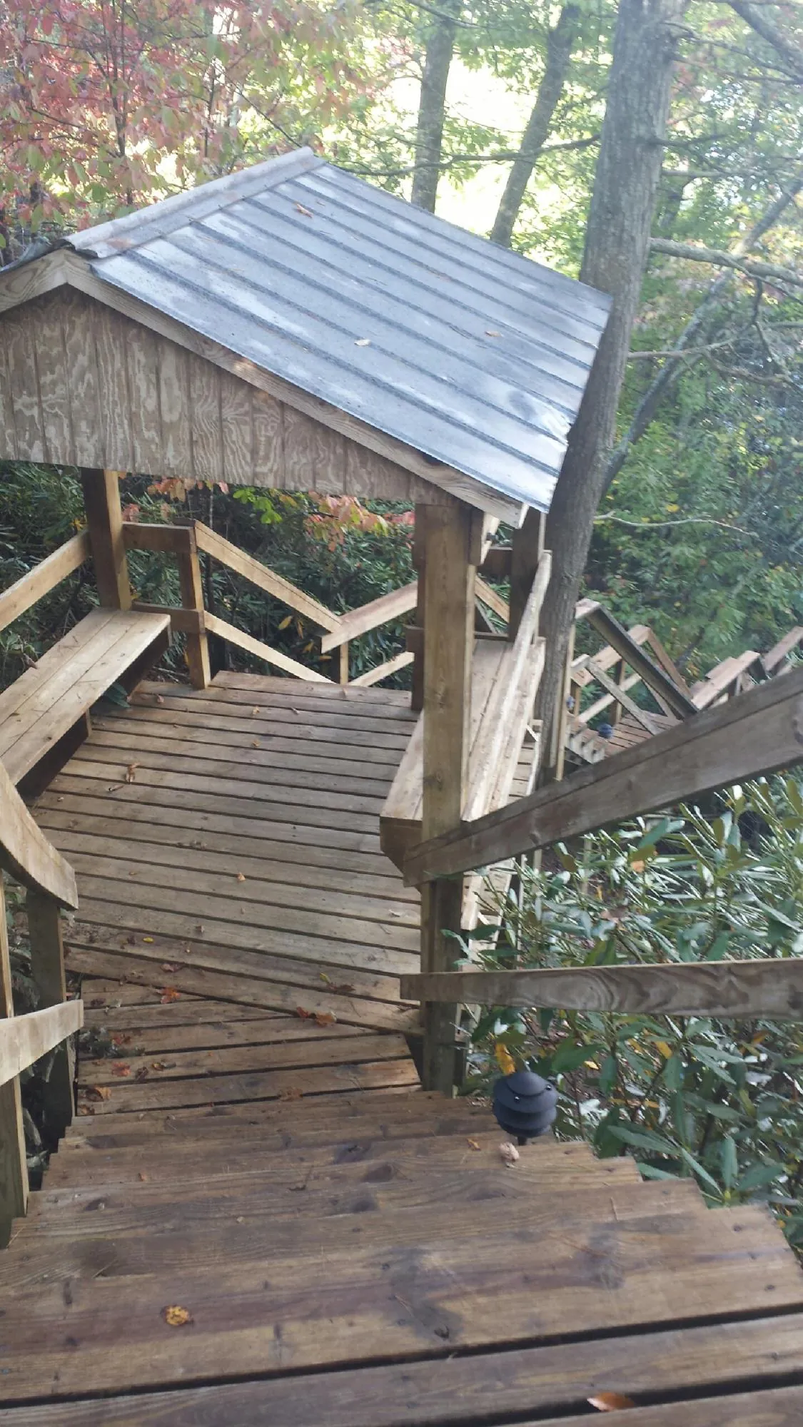 Metal roofed shelter over wooden steps on a wooded walkway — Skylight Repair & Installation work by our crew in Steubenville