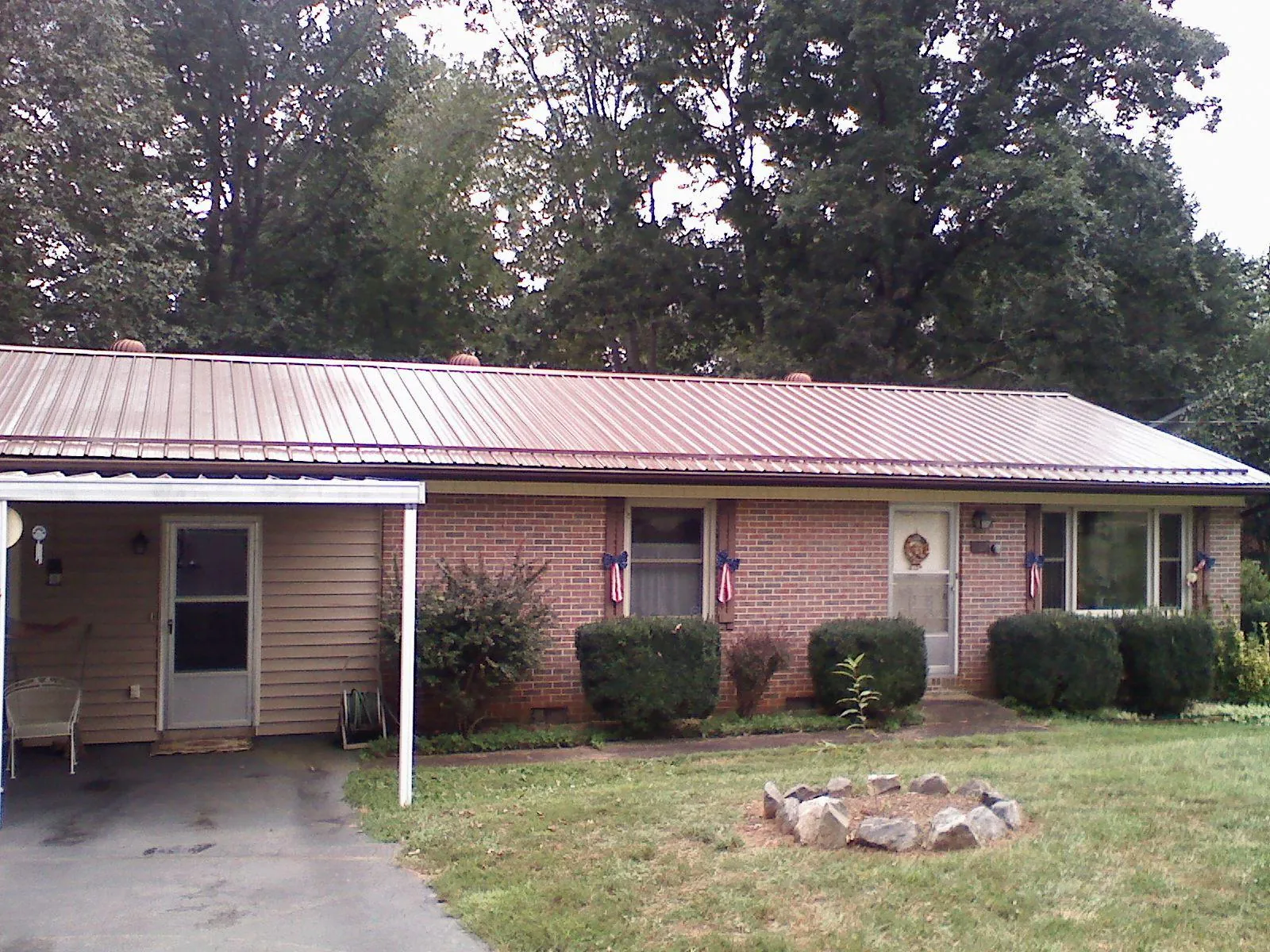 Bronze metal roof and carport on a brick ranch home — Roof Repair work by our crew in Steubenville
